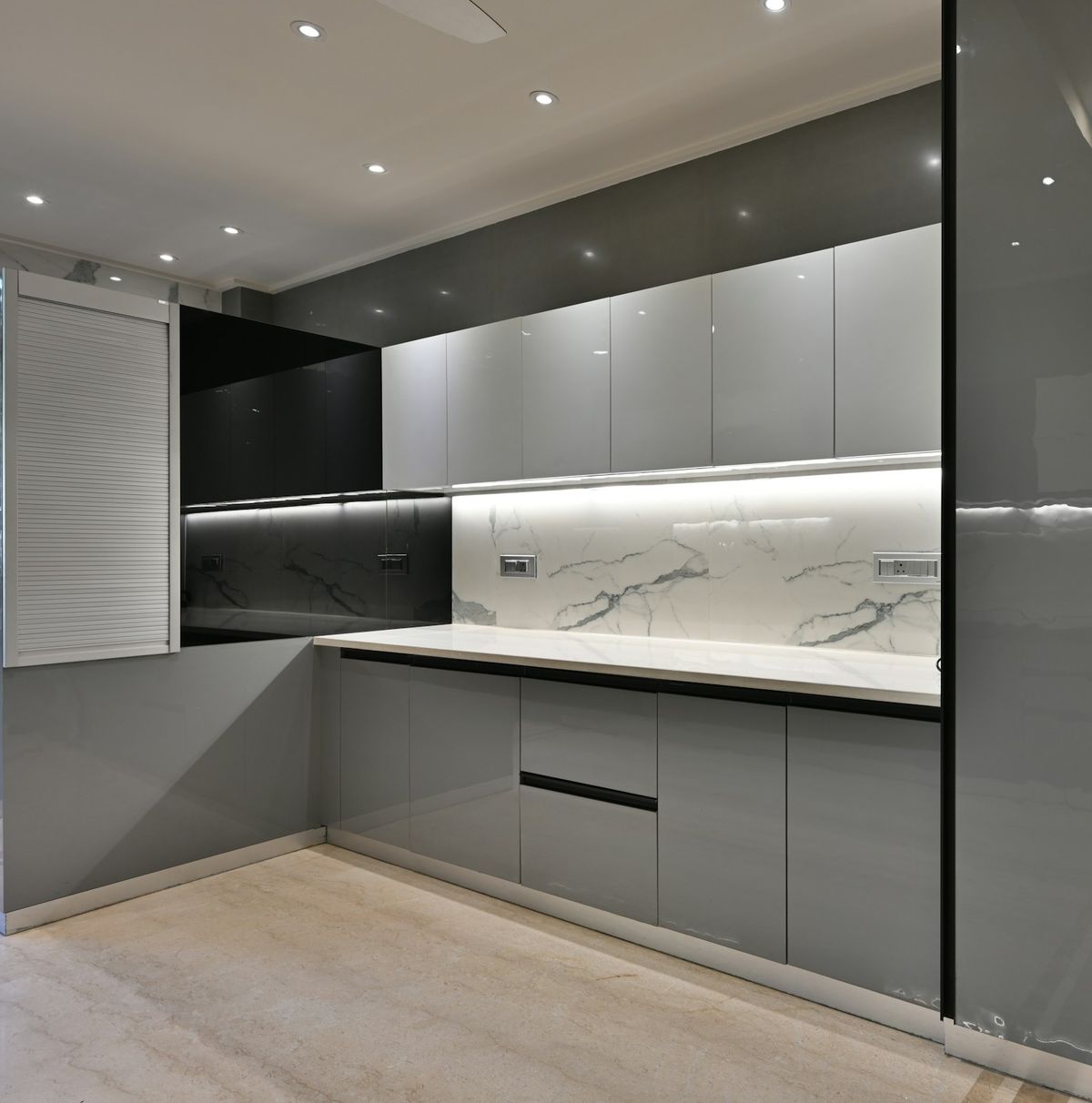 Greeploze keuken met hoogglans fronten in grijs en een witte achterwand met marmerlook